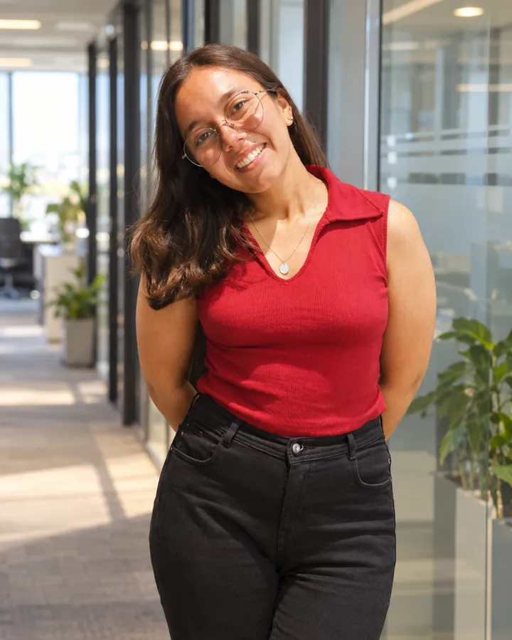 A professional smiling in an office corridor